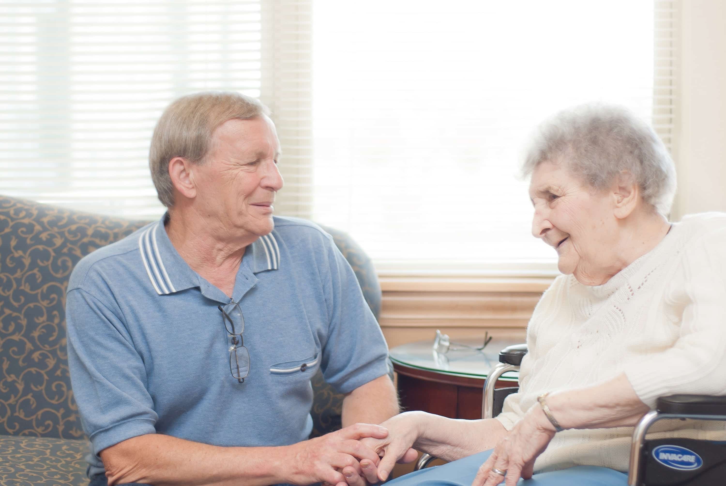 Son and mother sitting together holding hands