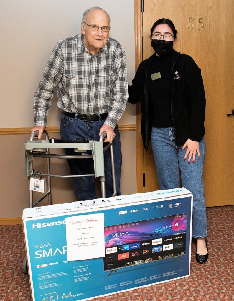 Stacy Ascencio Timbers of Shorewood Leasing Coordinator passes out a television to resident Bill R.