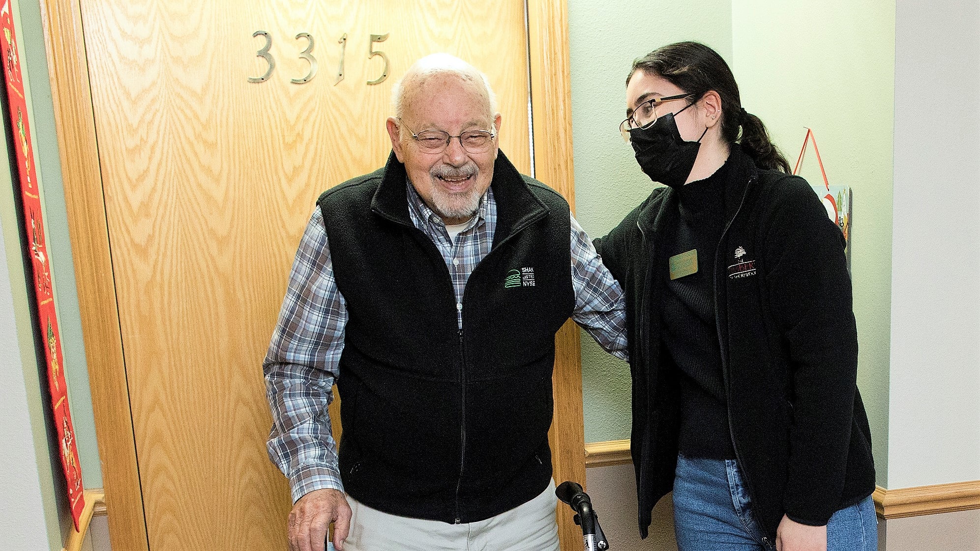 Stacy Ascencio Timbers of Shorewood Leasing Coordinator passes out a television to resident Jim McKeever