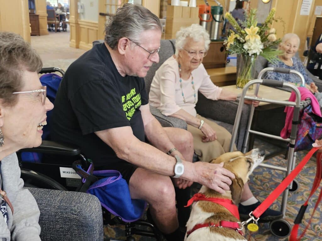 Maya the therapy dog and two seniors from the Timbers of Shorewood