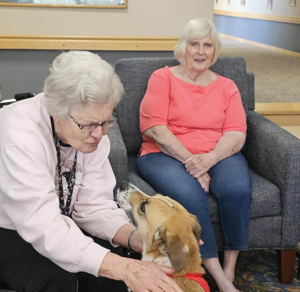 Maya the therapy dog and two seniors from the Timbers of Shorewood