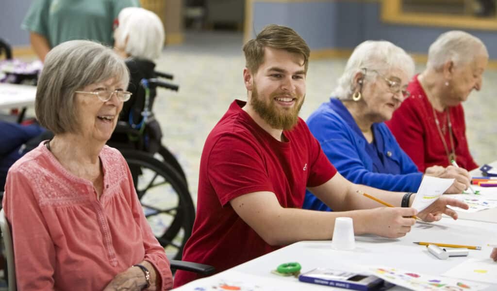 Timbers of Shorewood resident Carolyn Minnick laughs with University of St Francis Cliff Vickers as they work together on art projects Wednesday, April 17, 2024, in Shorewood, Ill. Photography by James C. Svehla