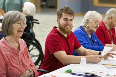 Timbers of Shorewood resident Carolyn Minnick laughs with University of St Francis Cliff Vickers as they work together on art projects Wednesday, April 17, 2024, in Shorewood, Ill. Photography by James C. Svehla