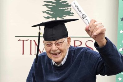 Senior citizen holds graduation certificate from Timbers Academy for Seniors.